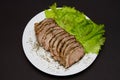 Sliced pork meat with lettuce leaves on a plate Royalty Free Stock Photo